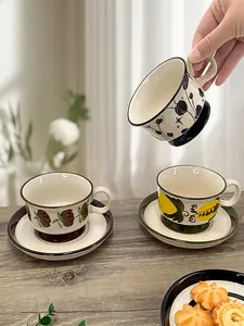 Detail of vintage hand-painted ceramic coffee cup set with floral and lemon patterns