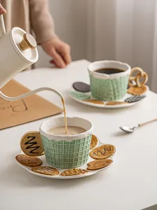 Macro shot of green grid ceramic cup with creative biscuit-shaped saucer pouring coffee