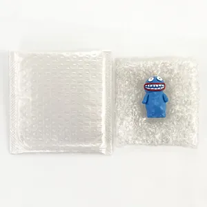 Blue resin cartoon figurine with big mouth shown with protective bubble wrap packaging