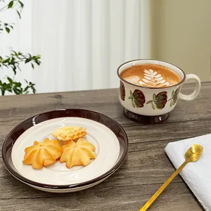 Detail of retro hand-painted ceramic coffee cup with floral pattern and latte art on wood table