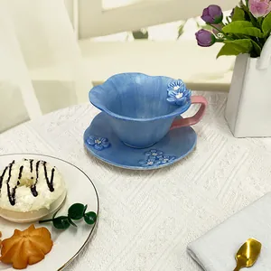 Handcrafted ceramic coffee cup and saucer set with 3D blue flower relief and pink handle
