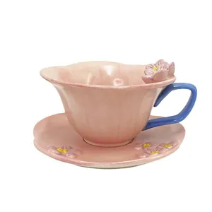 Pink ceramic coffee cup and saucer set with 3D floral relief and blue handle