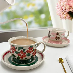 Hand-painted vintage ceramic coffee cup and saucer set with floral patterns and tea setting