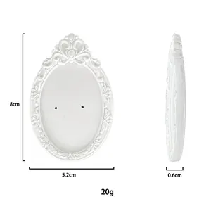 Macro view of white resin jewelry display stand with retro embossed floral pattern