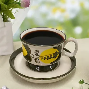Detailed close-up of hand-painted ceramic coffee cup and saucer with yellow floral patterns