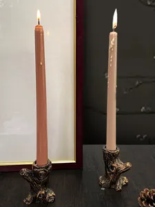 Dettaglio di portacandele a forma di ceppo con trama in legno e candele accese