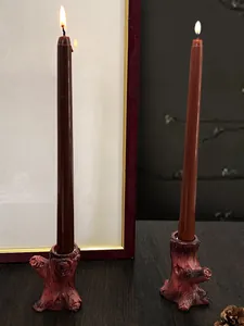 Dettaglio di portacandele vintage a forma di ceppo con candele accese in un set caldo