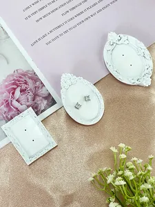 Macro shot of square-cut cubic zirconia earrings on a vintage prop display stand