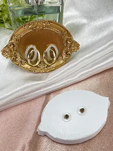 Detailed view of intertwined gold hoop earrings with white zircon on a vintage tray