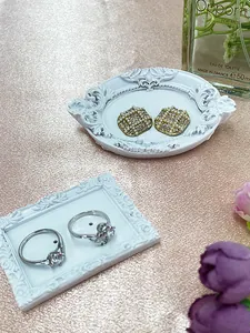 Detail of elegant gold pearl earrings and zircon rings on a vintage display tray