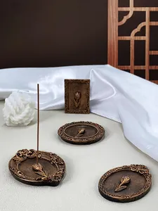 Detail of vintage bronze tulip embossed incense holders on elegant white silk and wood screen