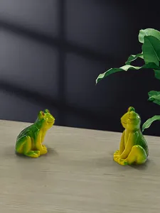 Macro detail of pair of resin frog garden figurines with green and yellow gradient finish