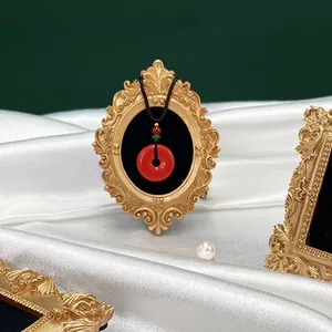 Pendentif en agate rouge dans un cadre doré vintage sur soie blanche gros plan