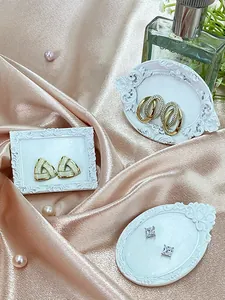 Detail view of vintage geometric earrings on ornate frames and silk background
