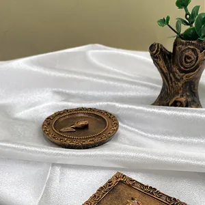 Detailed macro view of vintage bronze resin coaster with embossed tulip and floral relief