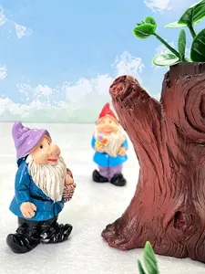Detail view of resin garden gnomes with purple and red hats in a miniature scene
