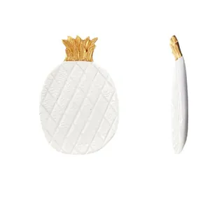 Minimalistisch wit ananas sieradendienblad met gouden bladgoud en reliëftextuur