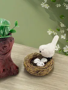 Dettaglio di un nido d'uccello in resina con uova bianche per decorazione da giardino