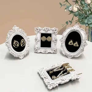 Vue détaillée de boucles d'oreilles dorées vintage et bracelet de perles sur cadre sculpté