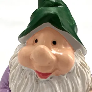 Close-up of a hand-painted resin garden gnome with a green hat and white beard detail