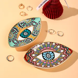 Detailed macro view of two evil eye ceramic jewelry trays with mandala patterns and gold rim