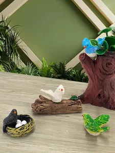 Dettaglio di un uccello blu in miniatura in resina su un tronco per decorazione da giardino