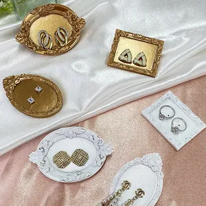 Vintage jewelry display set with gold earrings and pearl pendants on silk background