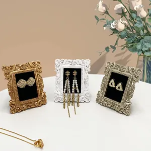 Cadre doré vintage présentant des boucles d'oreilles et colliers élégants pour photo