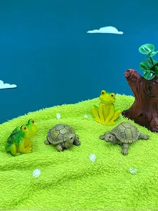 Miniature resin figurines featuring detailed cartoon frogs and turtles on green faux grass