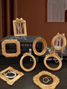 Dettaglio di cornici in miniatura dorate vintage con intagli barocchi per gioielli di lusso