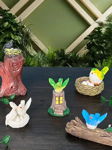 Dettaglio di varie statuette di uccelli in resina su ceppi per decorazione da giardino