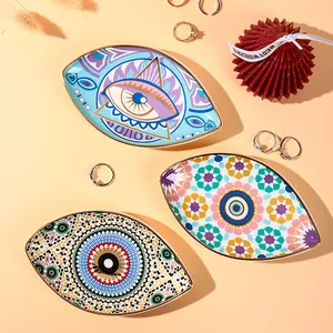 Close-up of ceramic evil eye jewelry trays with gold edges and bohemian patterns