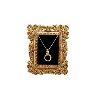 Collier à pendentif cercle doré vintage présenté dans un cadre à relief rétro orné