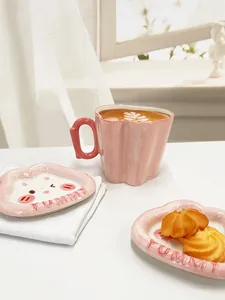 Détail d'une tasse en céramique rose à texture ondulée et soucoupe YUMMY en forme de nuage