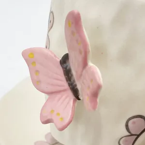 Dettaglio macro della farfalla 3D in ceramica fatta a mano su tazza di porcellana
