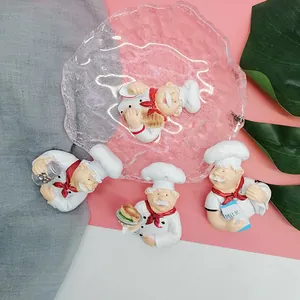 Detailed view of four resin chef figurines holding food, used as wall hooks or decor