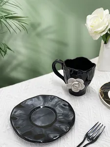 Detailed view of black ceramic coffee cup with 3D white rose and textured edge