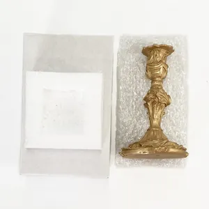 Baroque style gold candle holder shown with protective foam and cardboard box packaging