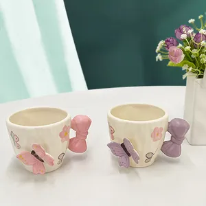Dettaglio di tazze da caffè in ceramica fatte a mano con manici a fiocco 3D e fiori