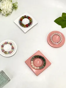 Close-up of diverse beaded bracelets with ceramic and resin charms on display trays