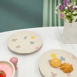 Vista dettagliata di un piatto in ceramica fatto a mano con fiori e farfalle