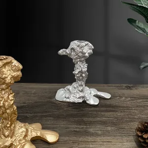 Detailansicht silberner und goldener Kerzenständer mit geschmolzener Lava-Textur