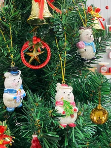 Close-up of three cute resin bear ornaments hanging on a festive Christmas tree branch