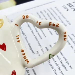 Detail van keramische koffiemok met harthandvat en All I Do Is For You tekstprint