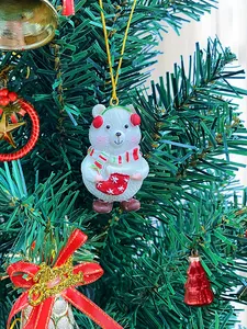 Close-up of resin Christmas bear ornament with red scarf on a decorated tree