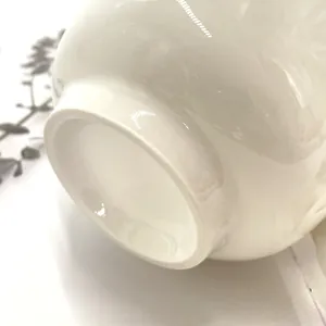 Detail shot of the smooth glazed ceramic base and bottom rim of a daisy coffee mug
