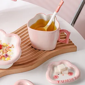 Service de table en céramique rose avec tasse lapin sur un plateau en bois