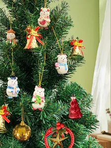 Detail of cute bear ornaments and gold bells hanging on a green Christmas tree branch
