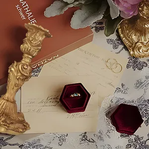 Detail of vintage gold ring with emerald green stone in red velvet jewelry gift box