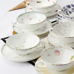 Vista dettagliata di tazze e piatti in ceramica con motivi floreali e bordi dorati